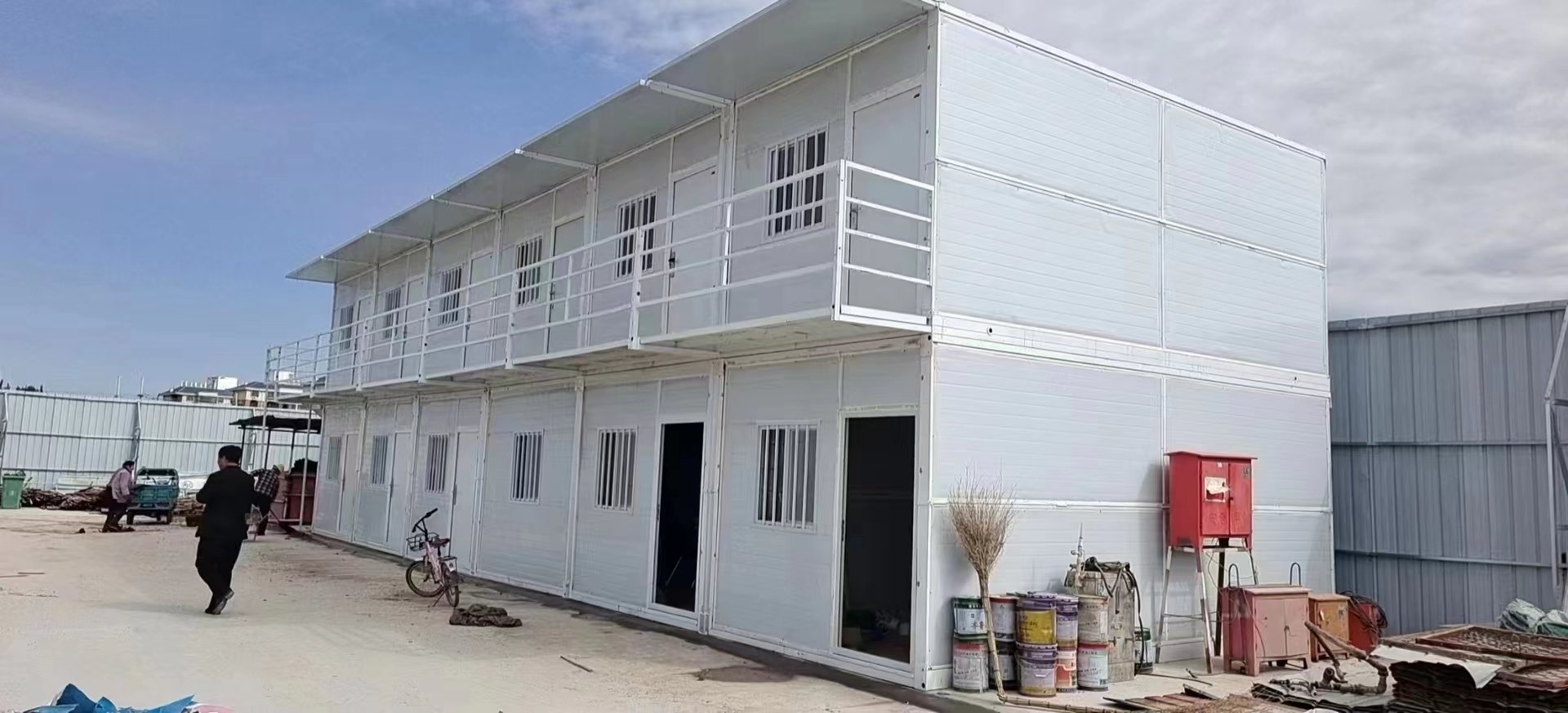 Folding prefab house with white wall panels and black frame