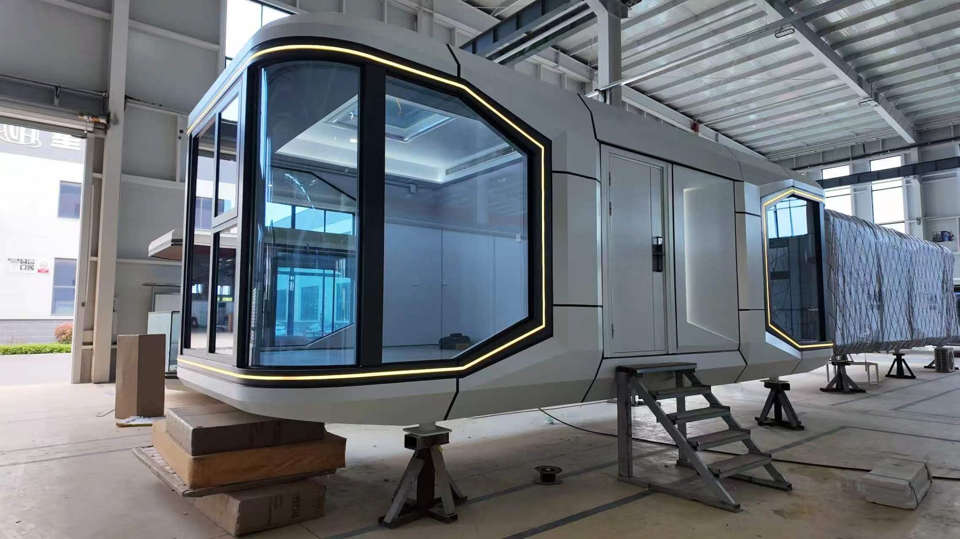 White space capsule cabin with large glass windows and outdoor deck